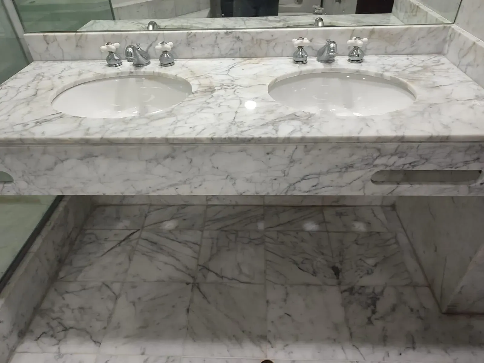 Marble double sink vanity with matching flooring.