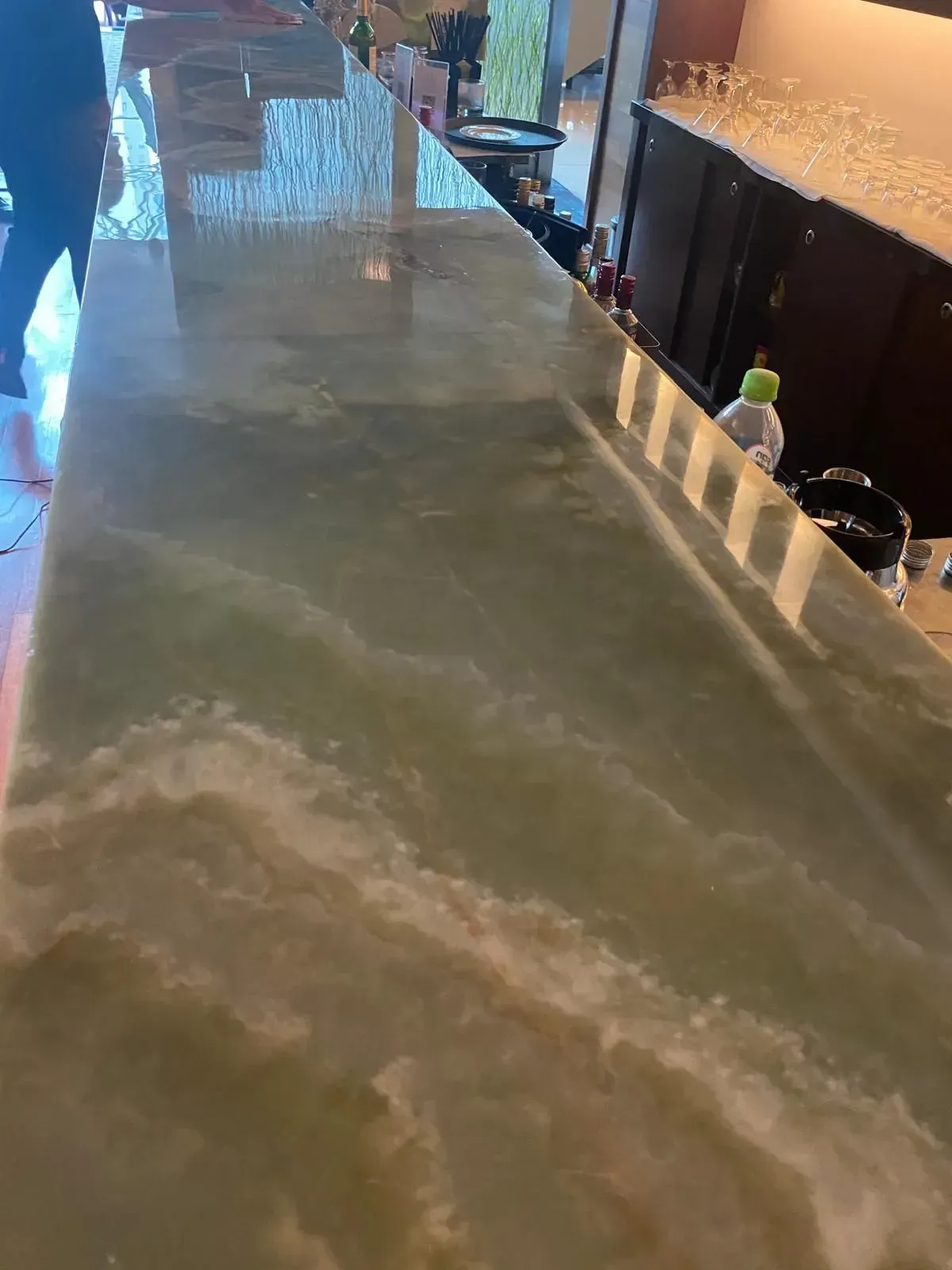 Green and white marbled bar surface with reflection.