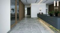 Modern lobby with marble floor, reception desk, wood paneling, and plants.