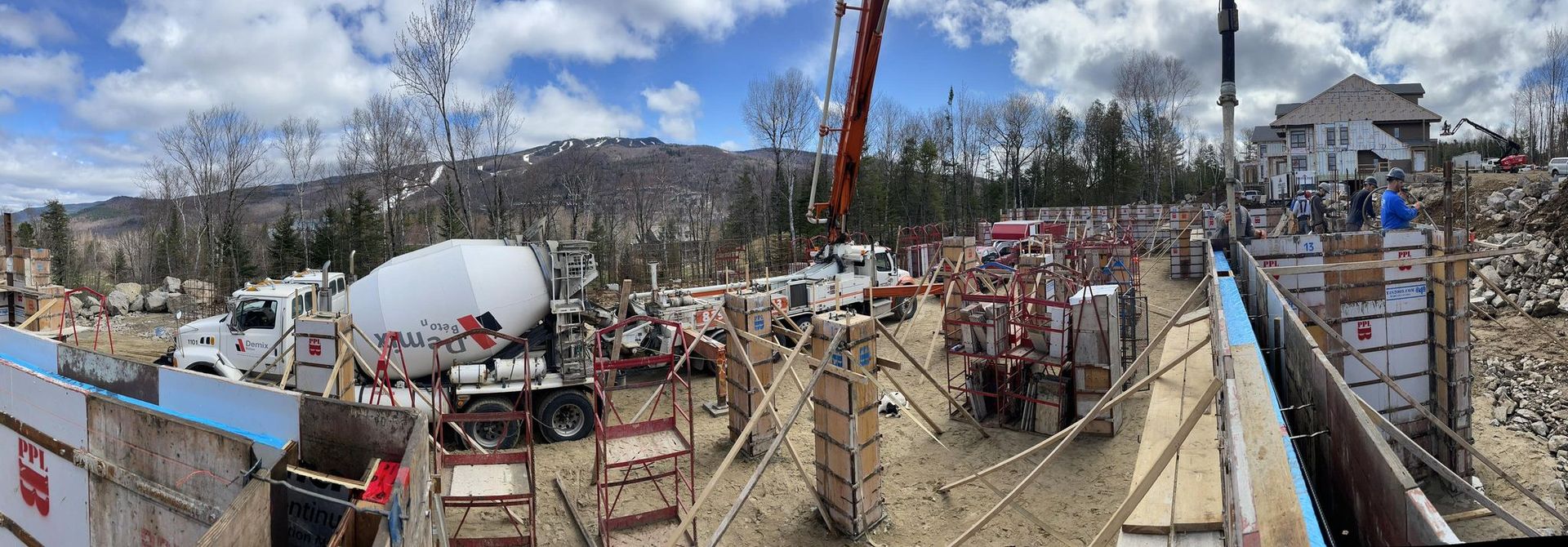 Une vue panoramique d'un chantier de construction avec une pompe à béton.