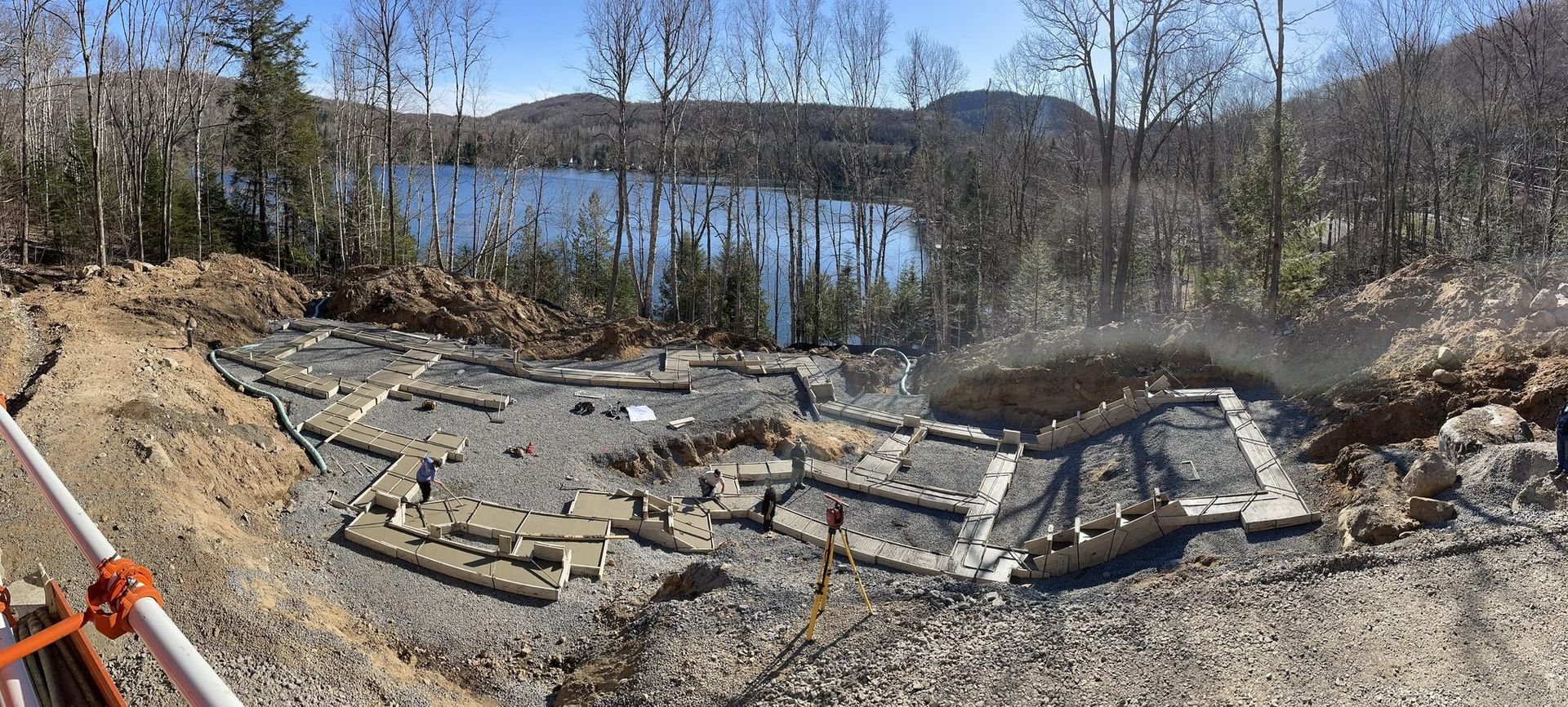Une vue panoramique d'un chantier de construction avec un lac en arrière-plan.