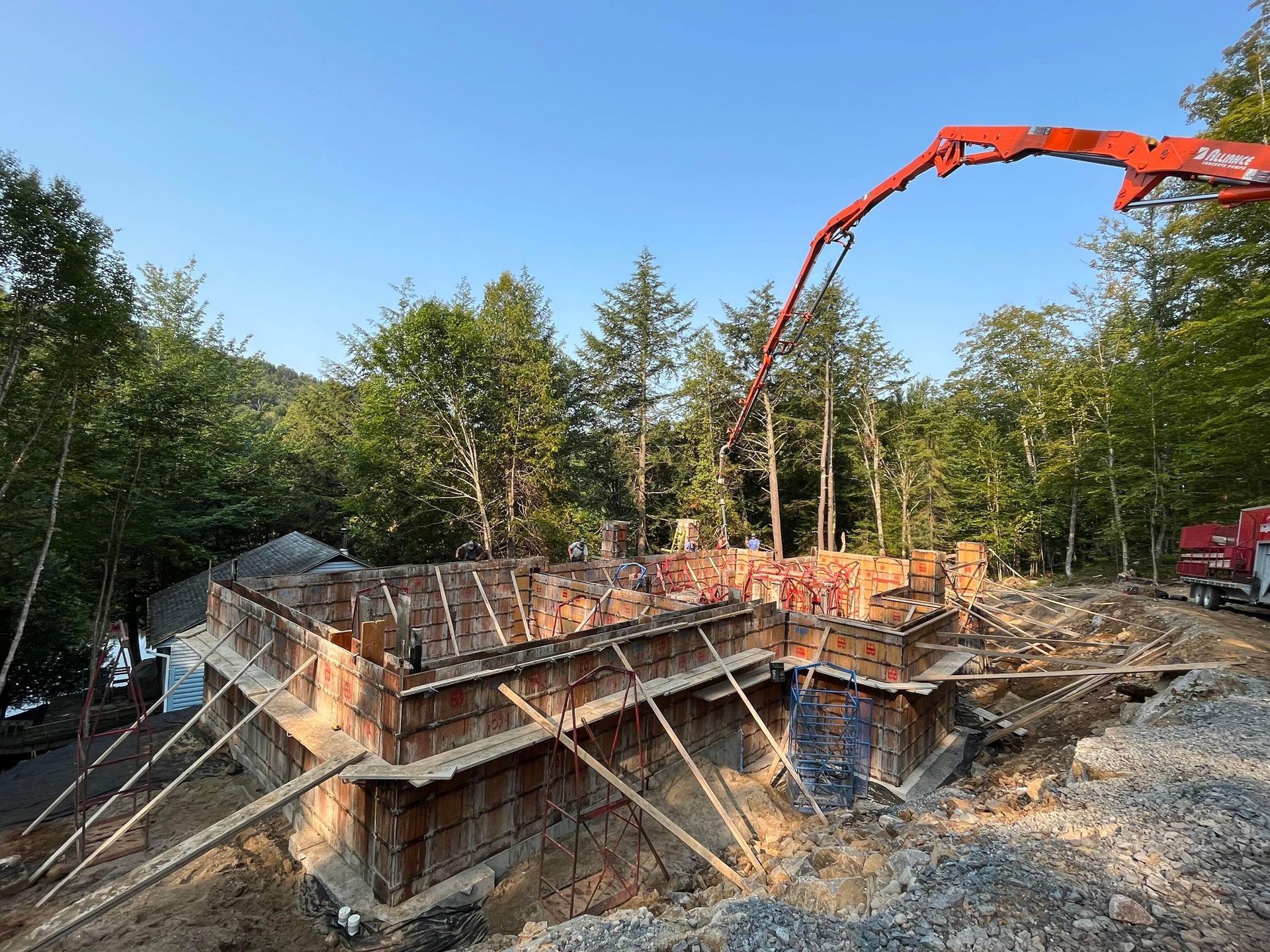Une pompe à béton coule du béton dans les fondations d'une maison.