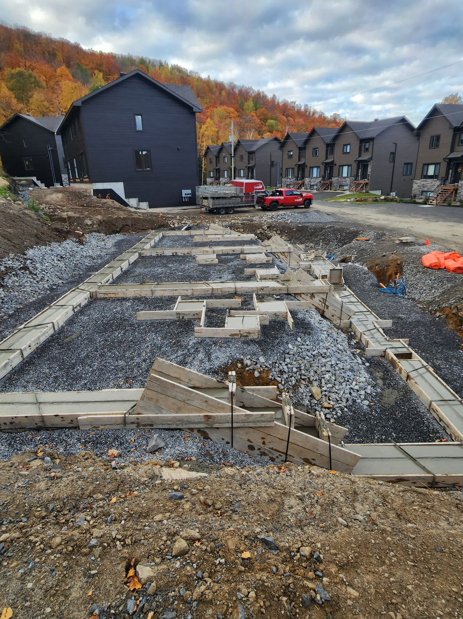 Un chantier de construction avec une rangée de maisons en arrière-plan.