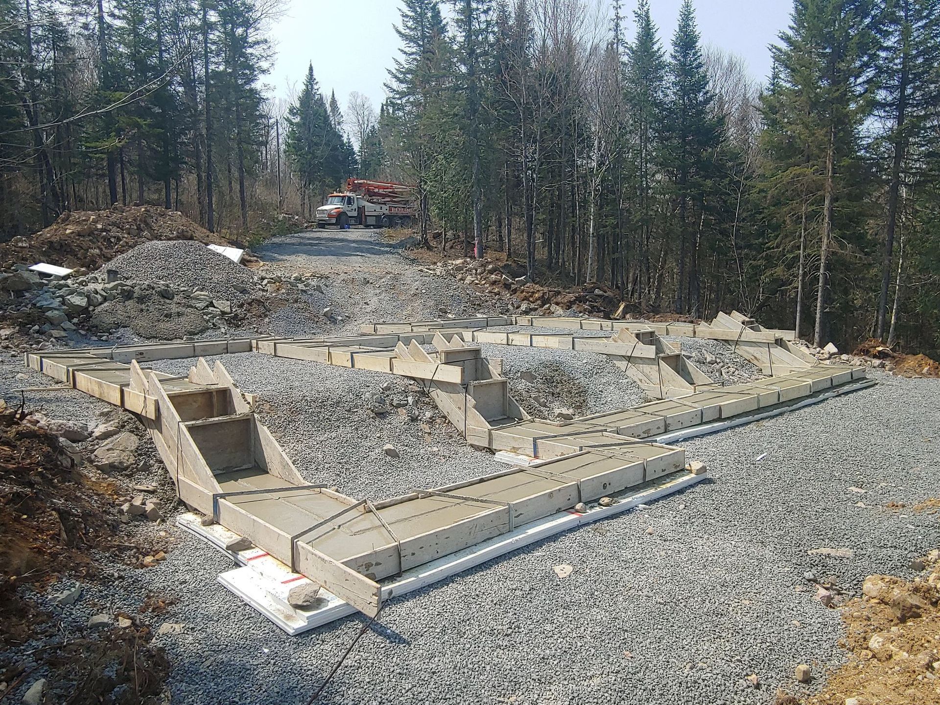 Une fondation en béton est en cours de construction au milieu d'une forêt.
