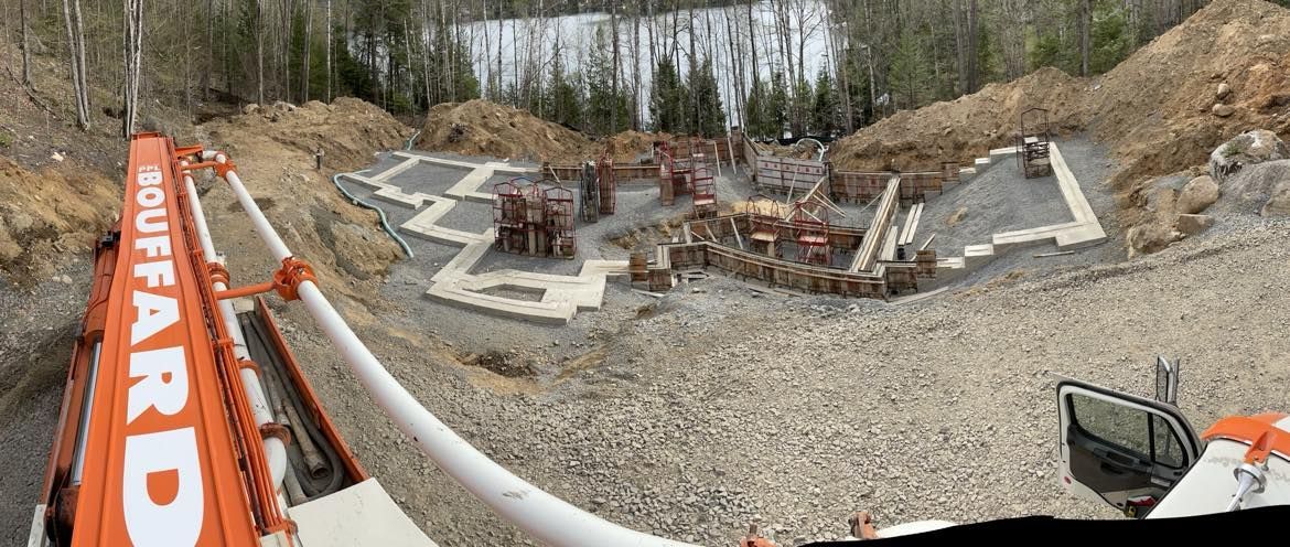 Une grande grue orange est assise au milieu d’un champ de terre.