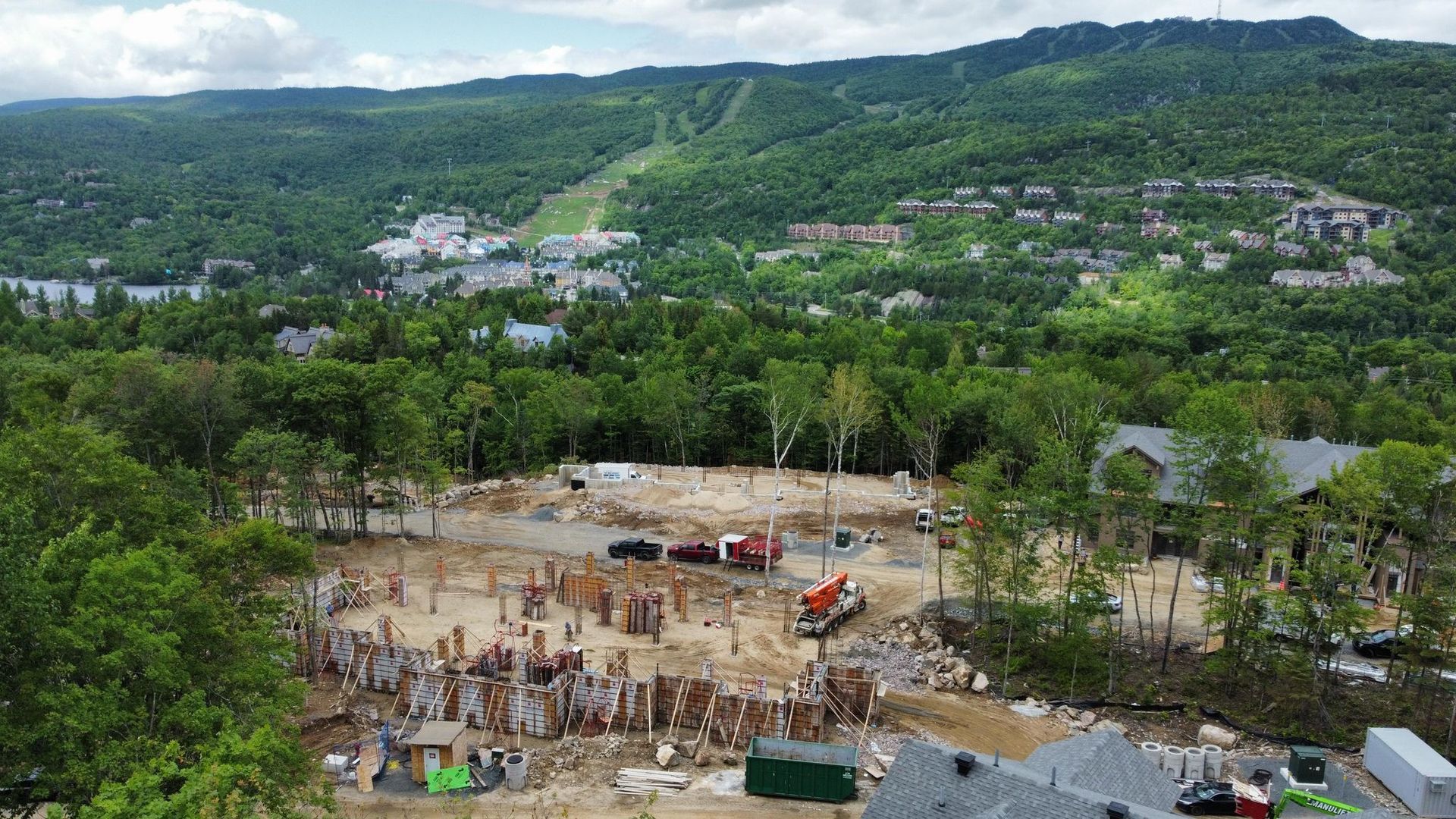 Une vue aérienne d’un chantier de construction avec une montagne en arrière-plan.