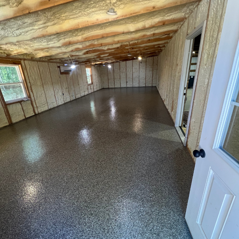 A large room with a concrete floor and a door.