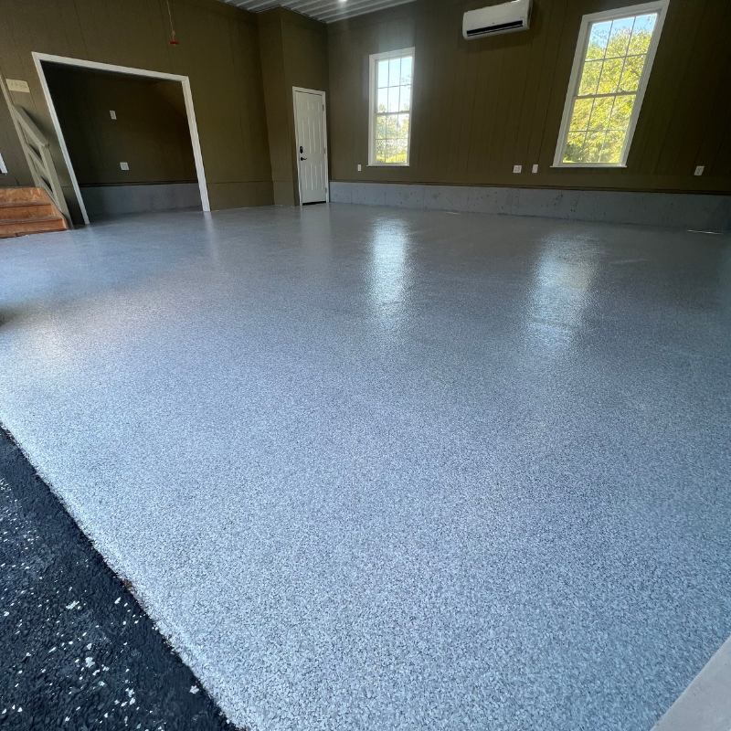 A garage with a gray floor and brown walls.