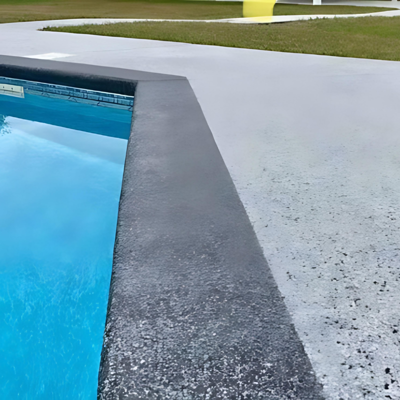 A swimming pool with blue water and a concrete border