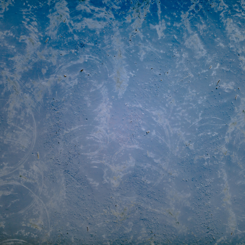 A close up of a blue and white marble texture with a blue sky in the background.