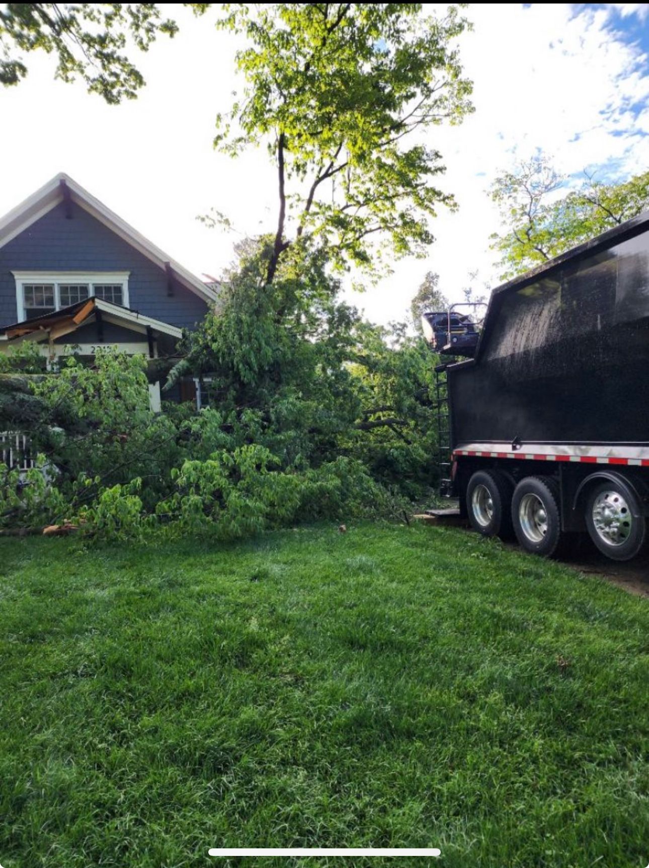 A black dump truck is parked in front of a house.