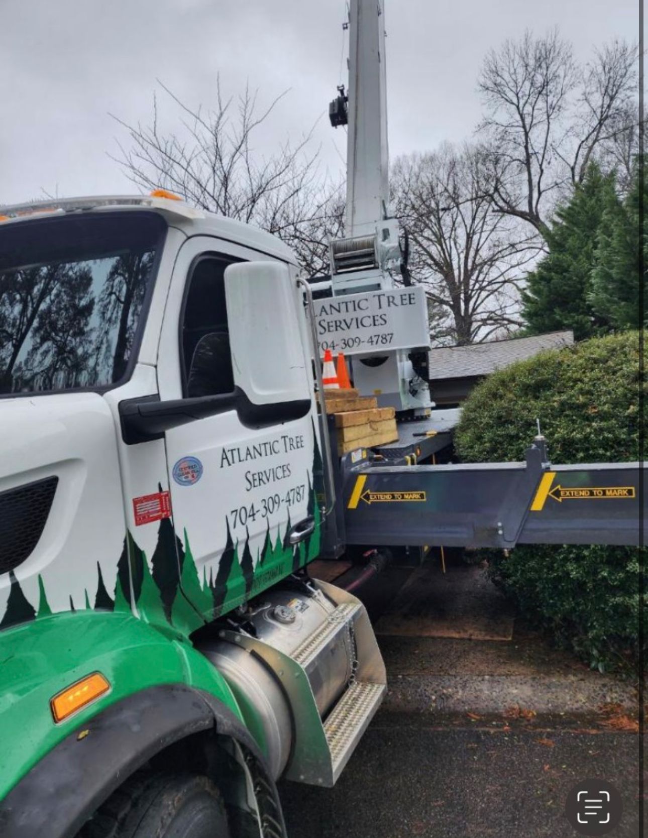 A green and white truck with atlantic tree services written on the side