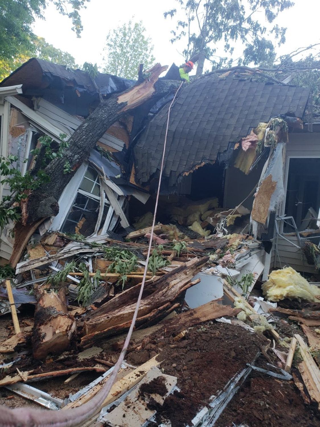 A house that has been demolished with a hose in the foreground