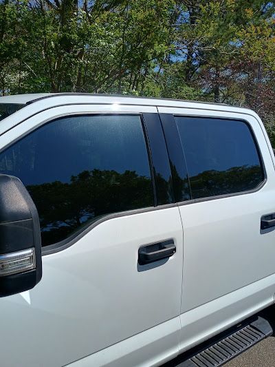 White pickup truck with tinted windows, parked outdoors on a sunny day.