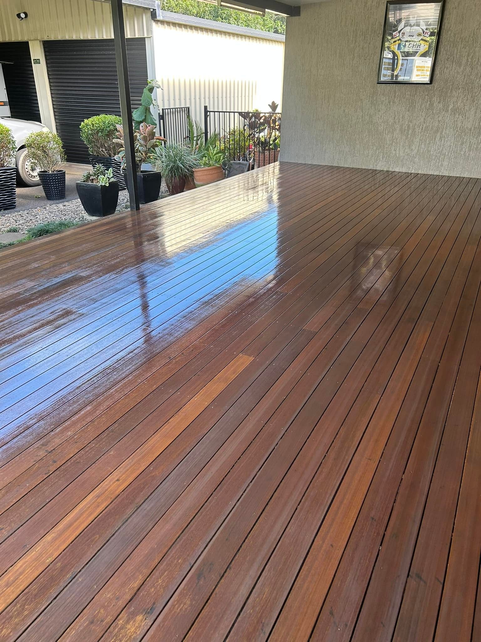 Wet Wooden Deck With Rows Of Planks Under An Overhang — Scott Johnston Floor Sanding in Mareeba, QLD