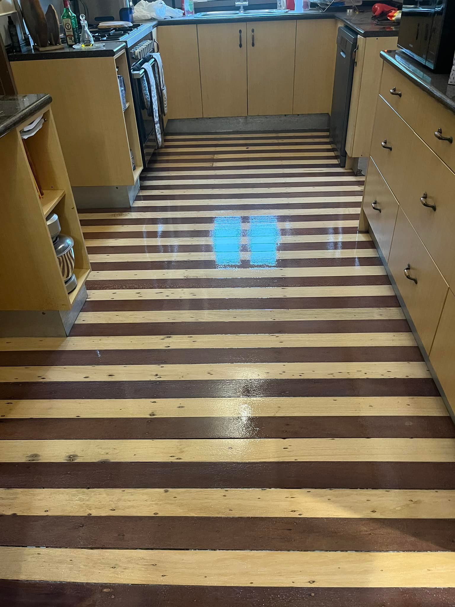 Wooden Kitchen Floor With Brown And Light Wood Stripes — Scott Johnston Floor Sanding in Mareeba, QLD