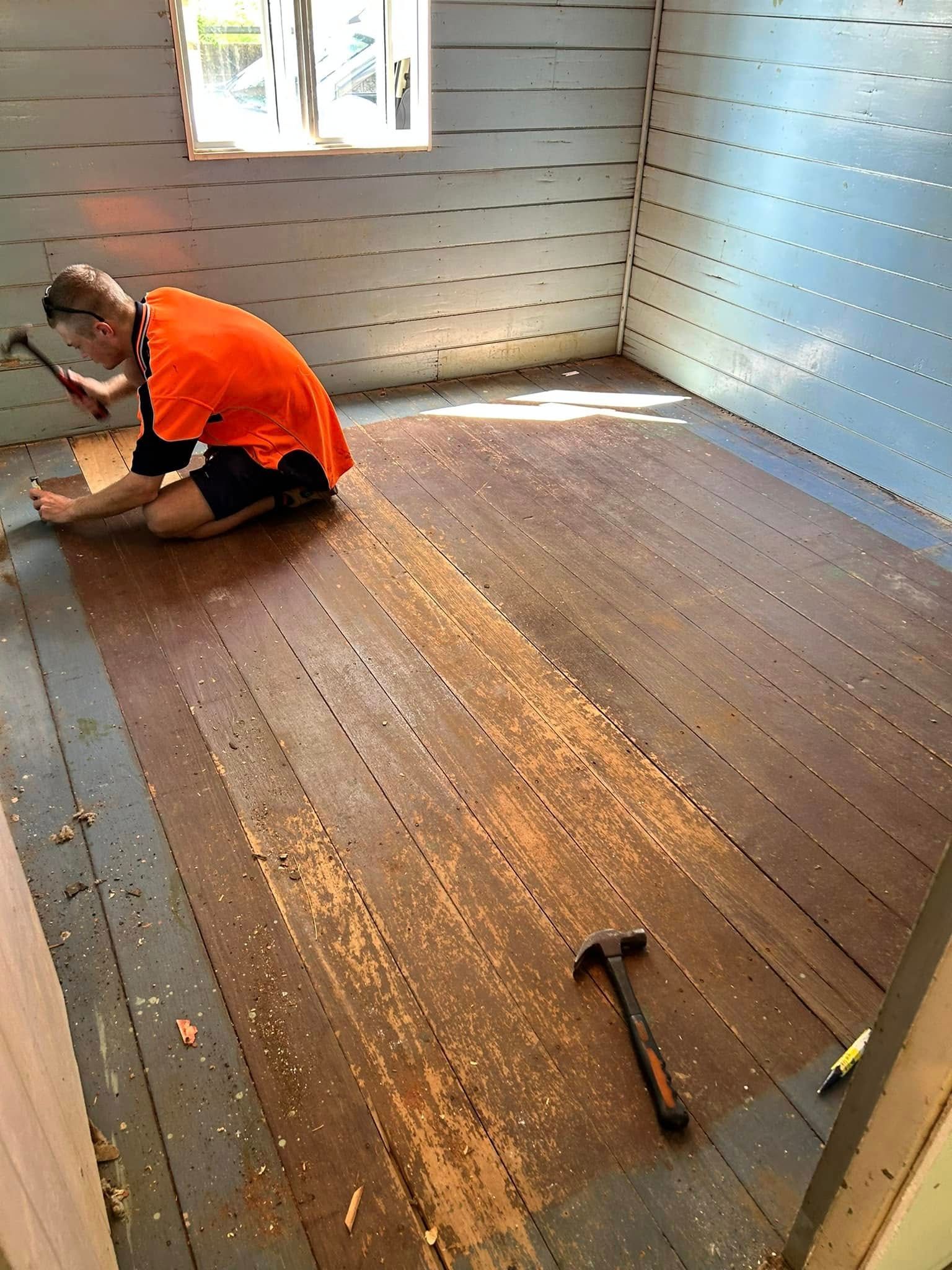 Person In Orange Shirt Removing Floorboards — Scott Johnston Floor Sanding in Bentley Park, QLD