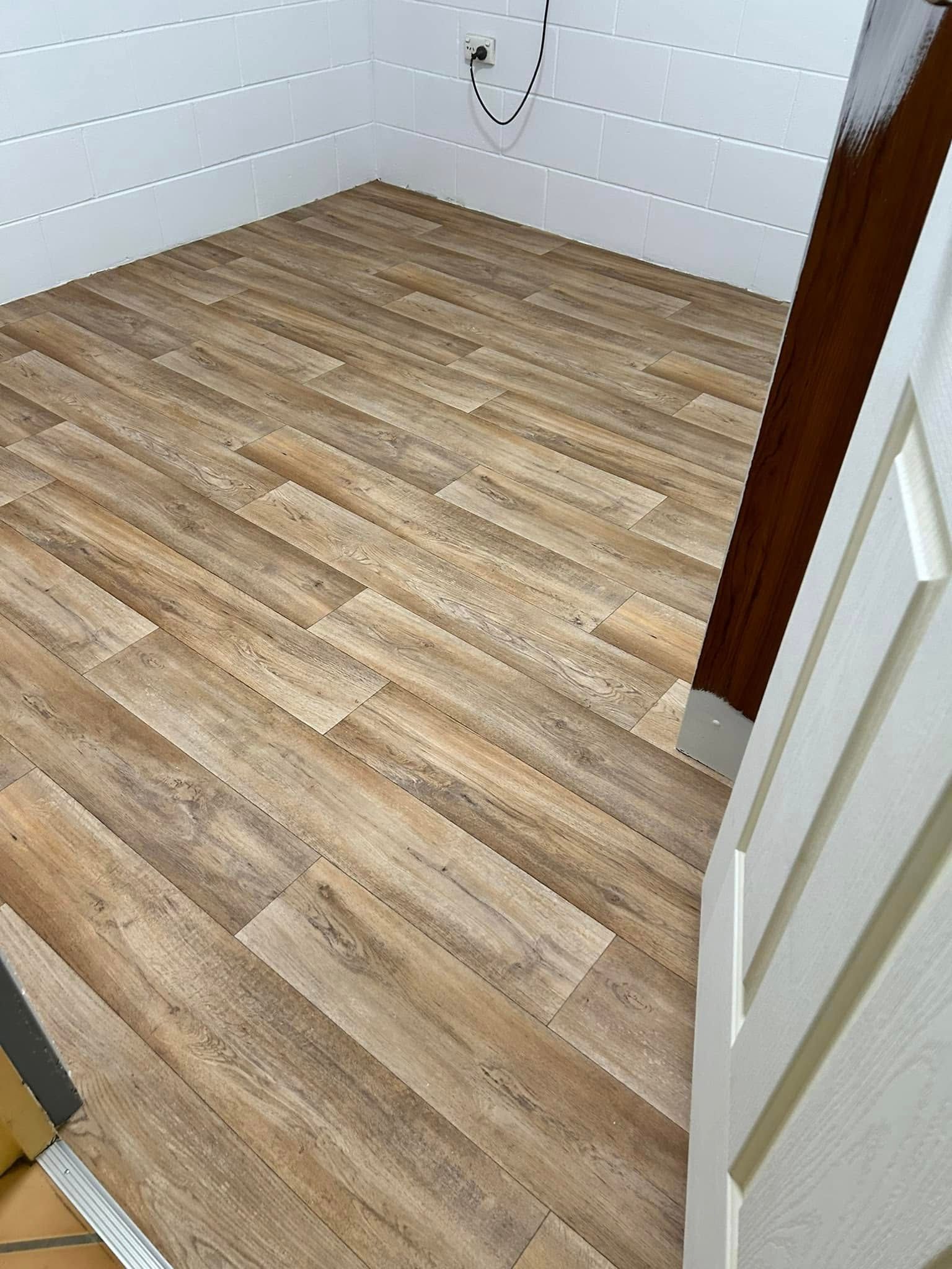 Wooden Plank Flooring In A Room With White Paneled Walls And A Door Frame — Scott Johnston Floor Sanding in Bentley Park, QLD
