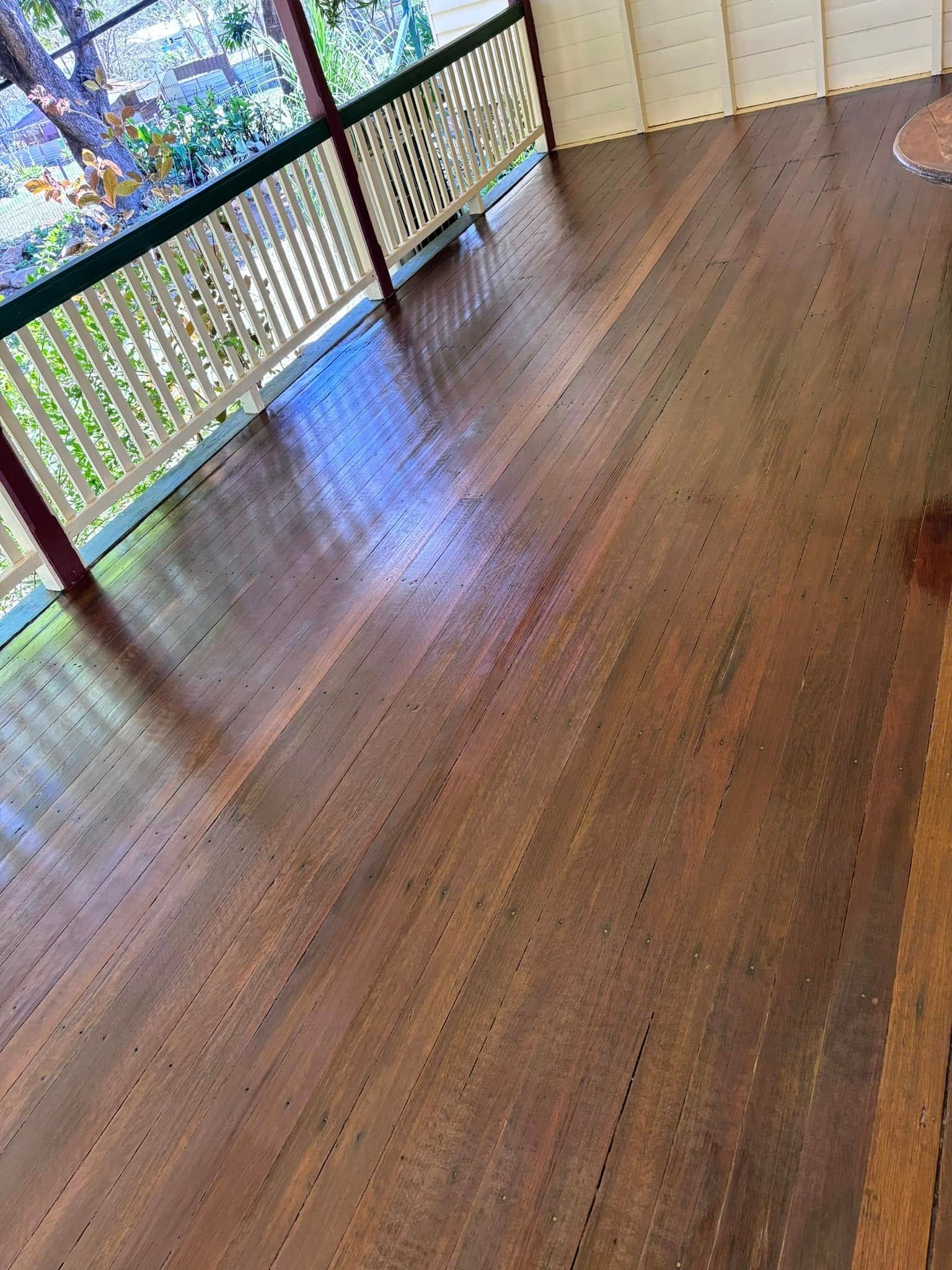 Wooden Deck With a Glossy Finish and a White Railing — Scott Johnston Floor Sanding in Bentley Park QLD