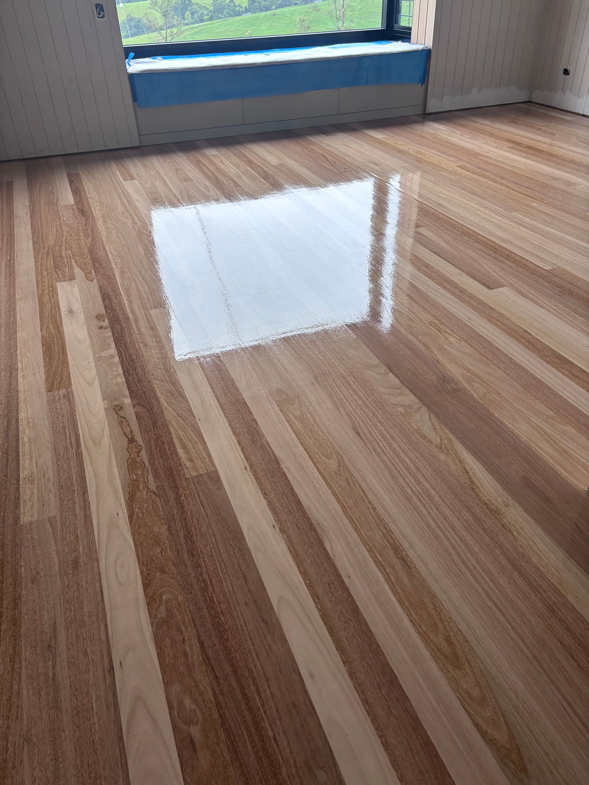 Shiny, Newly Finished Wooden Floorboards Reflecting Light — Scott Johnston Floor Sanding in Bentley Park QLD