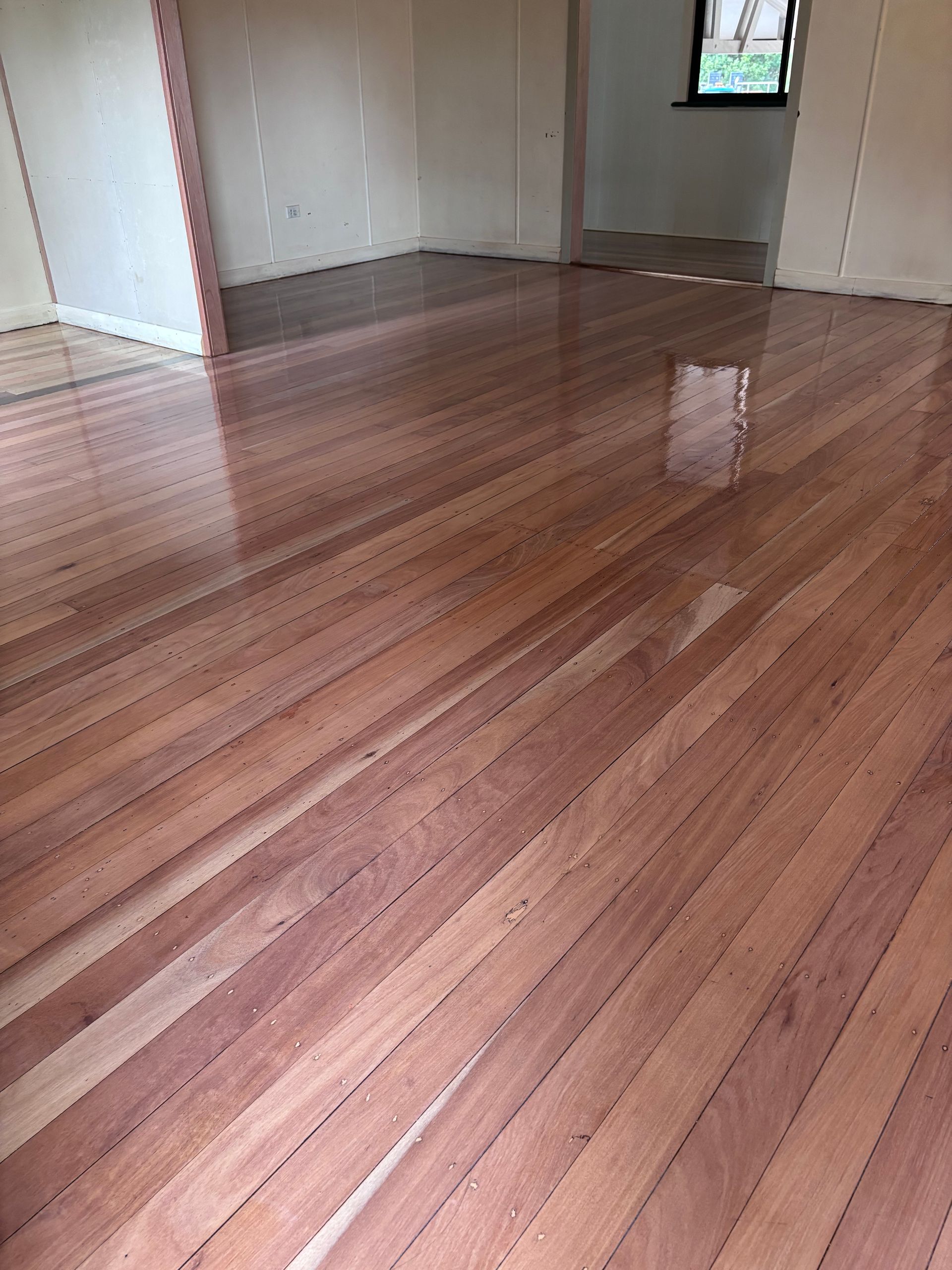 Polished, Reddish-brown Wooden Floor in a Room — Scott Johnston Floor Sanding in Bentley Park QLD