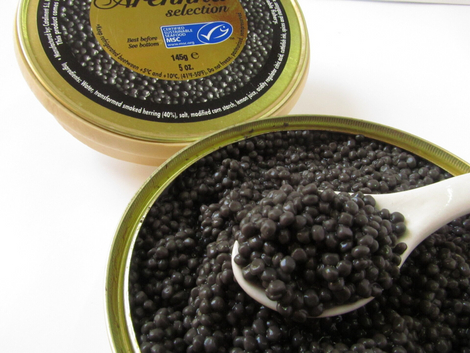 Caviar in a white bowl and on a spoon