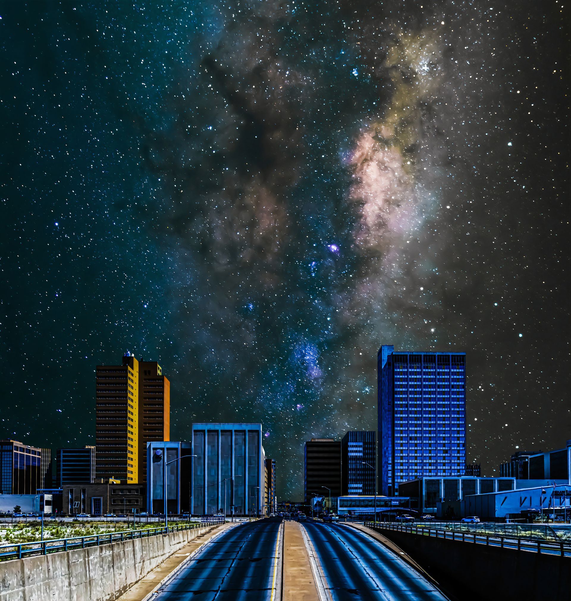 A city at night with a galaxy in the sky