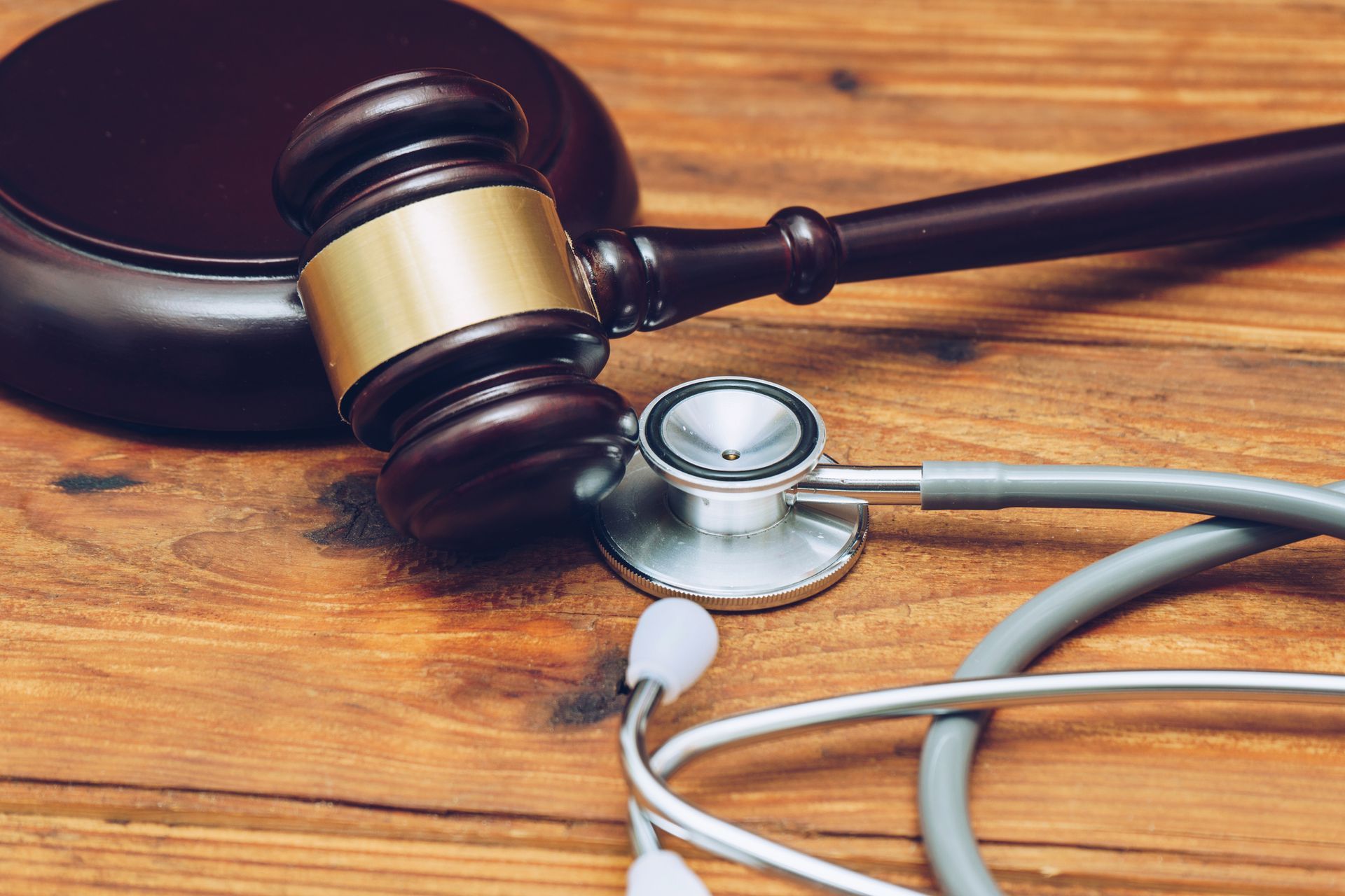 Judge gavel and stethoscope on wooden table symbolizing medical law and healthcare justice.