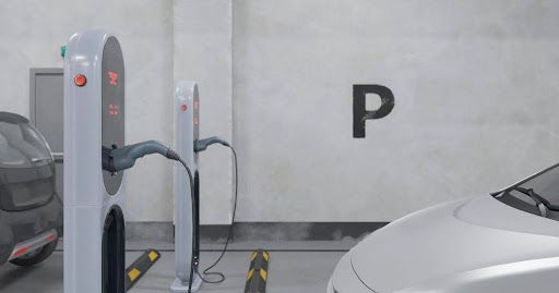 A car is being charged at a charging station in front of a house.