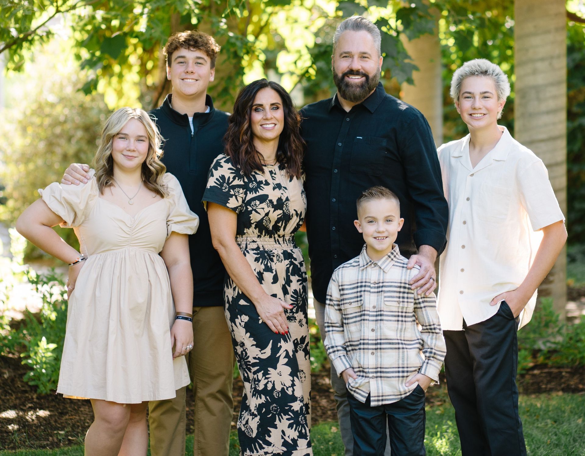A family is posing for a picture together in a park.