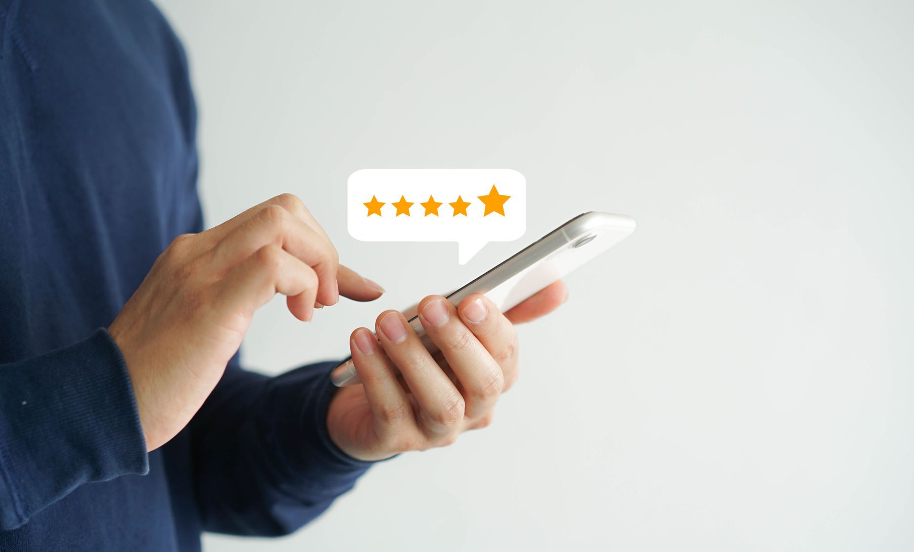 A person is holding a cell phone with a speech bubble with a star on it.