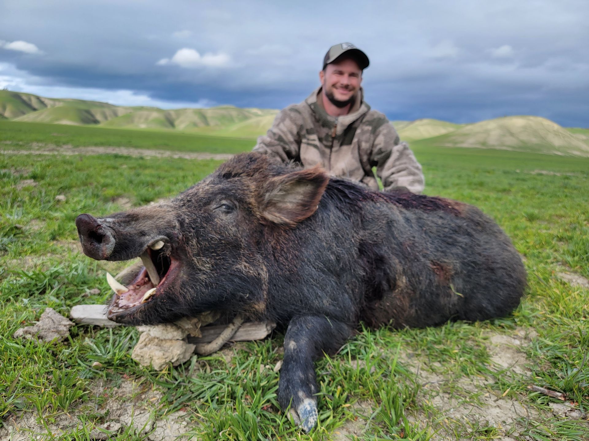 Successful wild hog hunt with hunter posing on Central Coast ranch