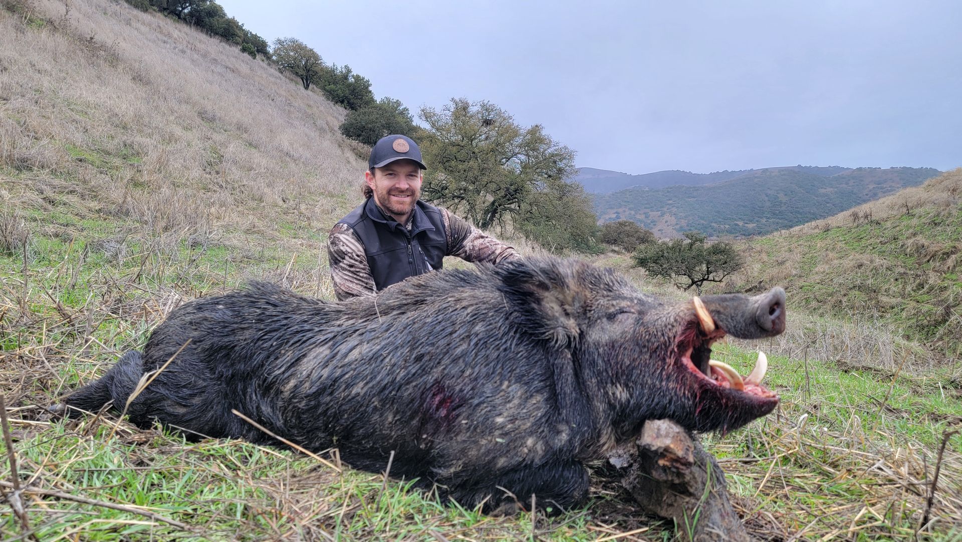 New hunter posing with mature boar during winter wild hog hunt