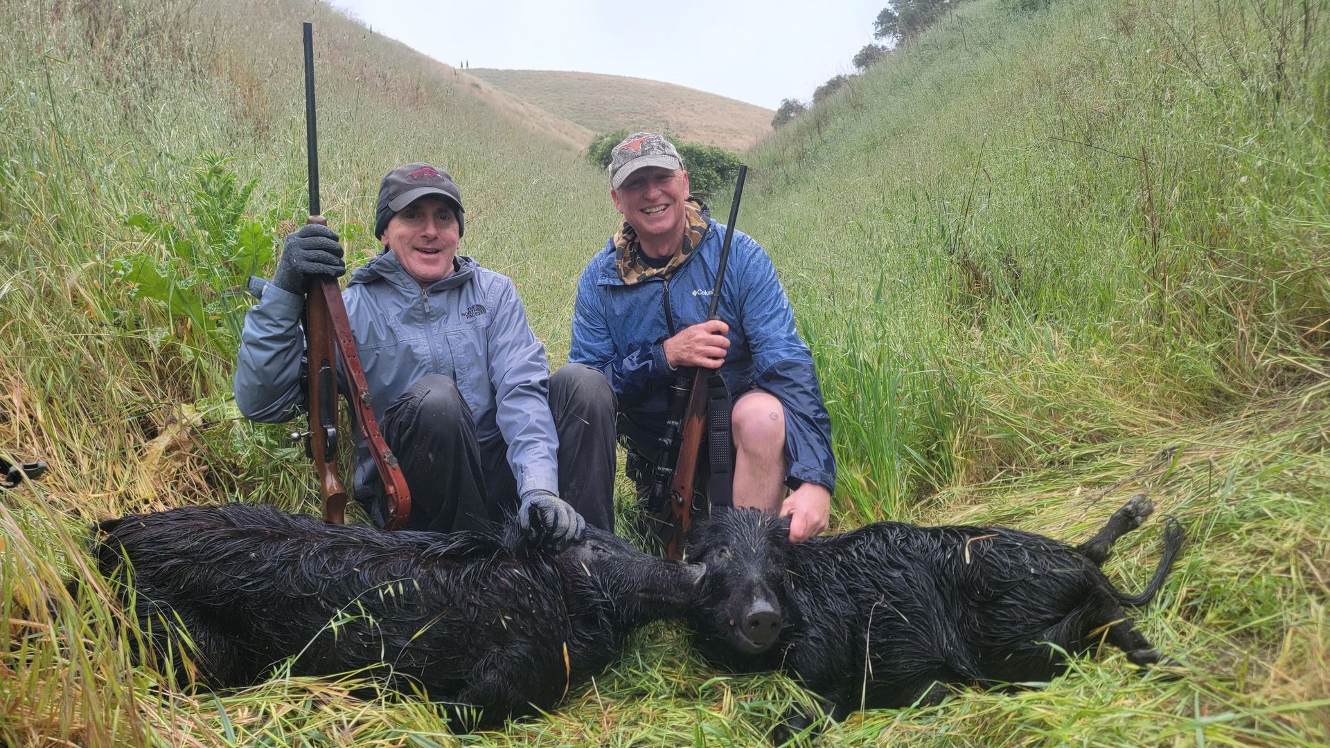 Friends with a couple wild hogs after successful weekend hunt