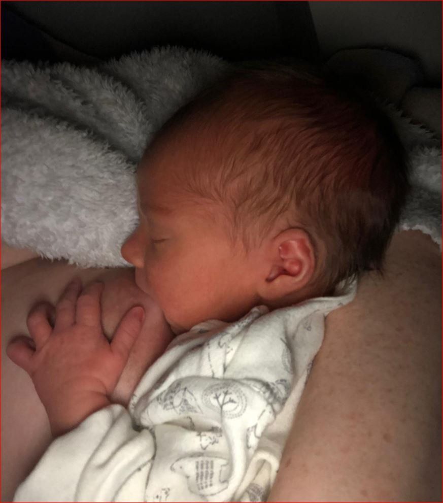 A newborn baby is sleeping on a woman 's chest