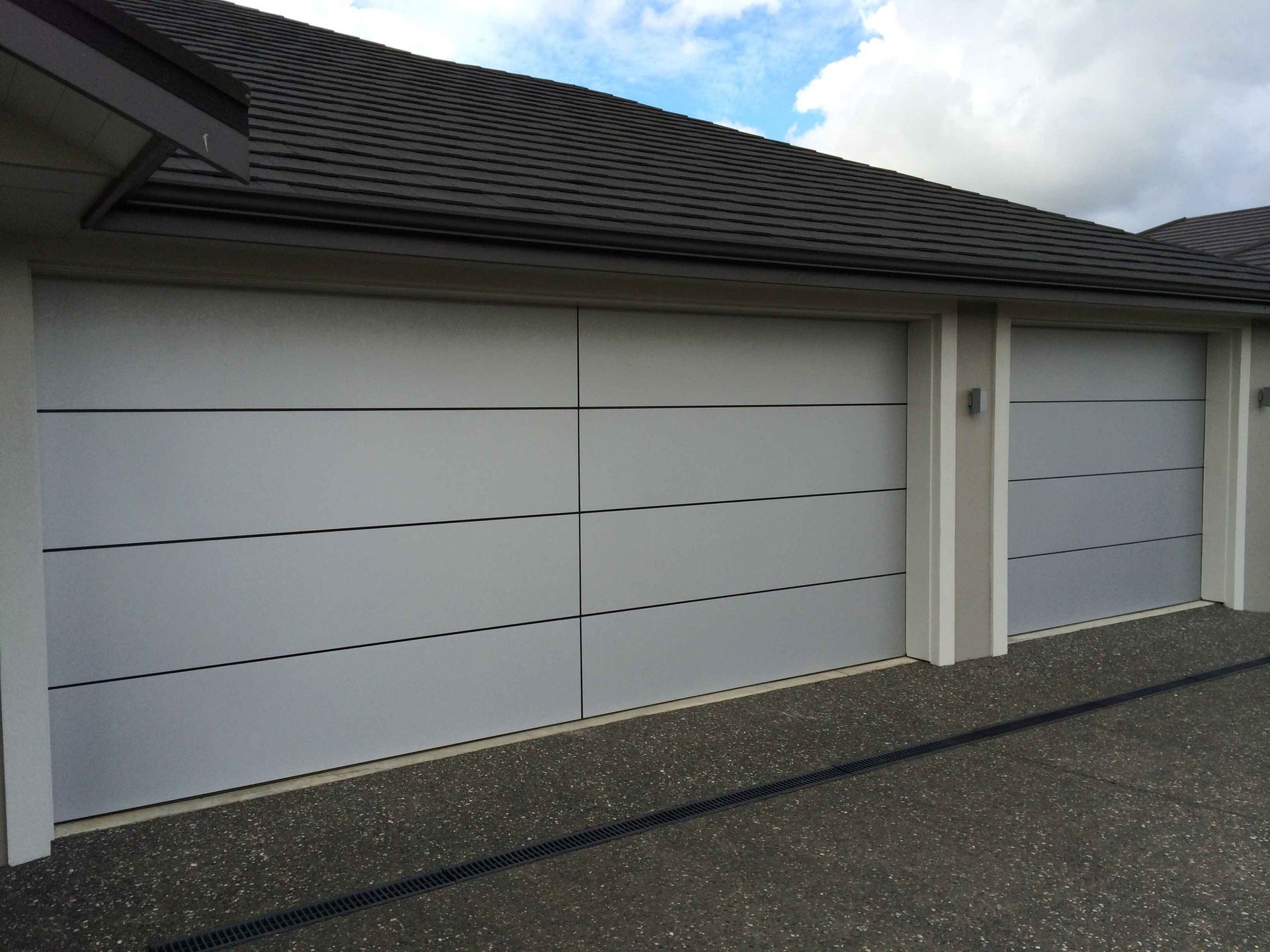 A row of white garage doors on a house