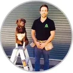 A man and a dog are standing next to each other on a ladder.