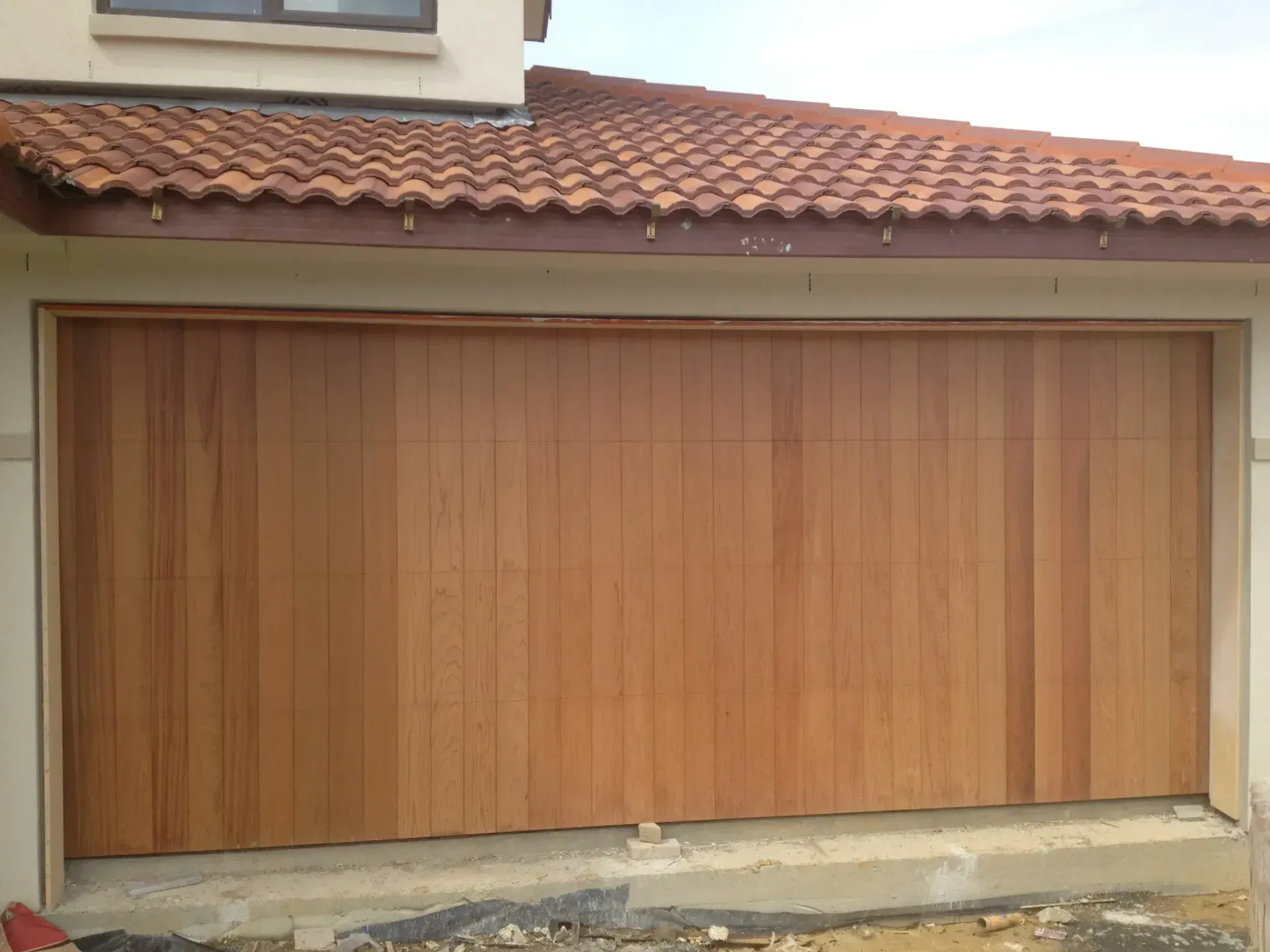 A large wooden garage door with a tiled roof