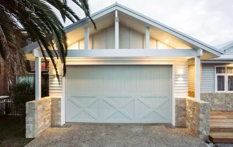 A house with a white garage door and a palm tree in front of it