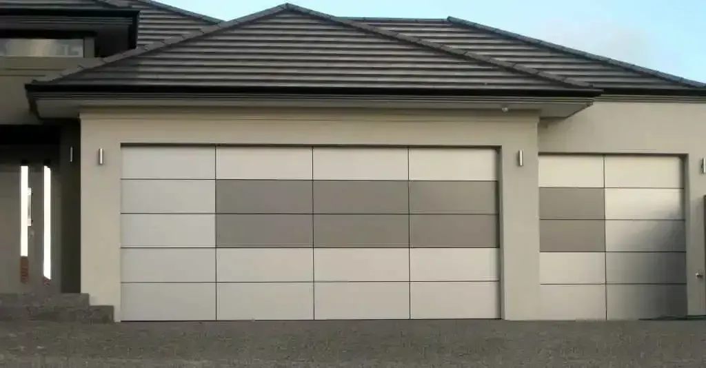 A modern house with two garage doors and a tiled roof.
