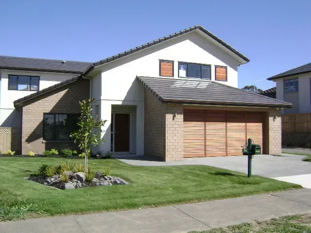A white house with a double wooden garage door