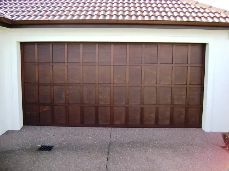 A large wooden garage door with a tiled roof