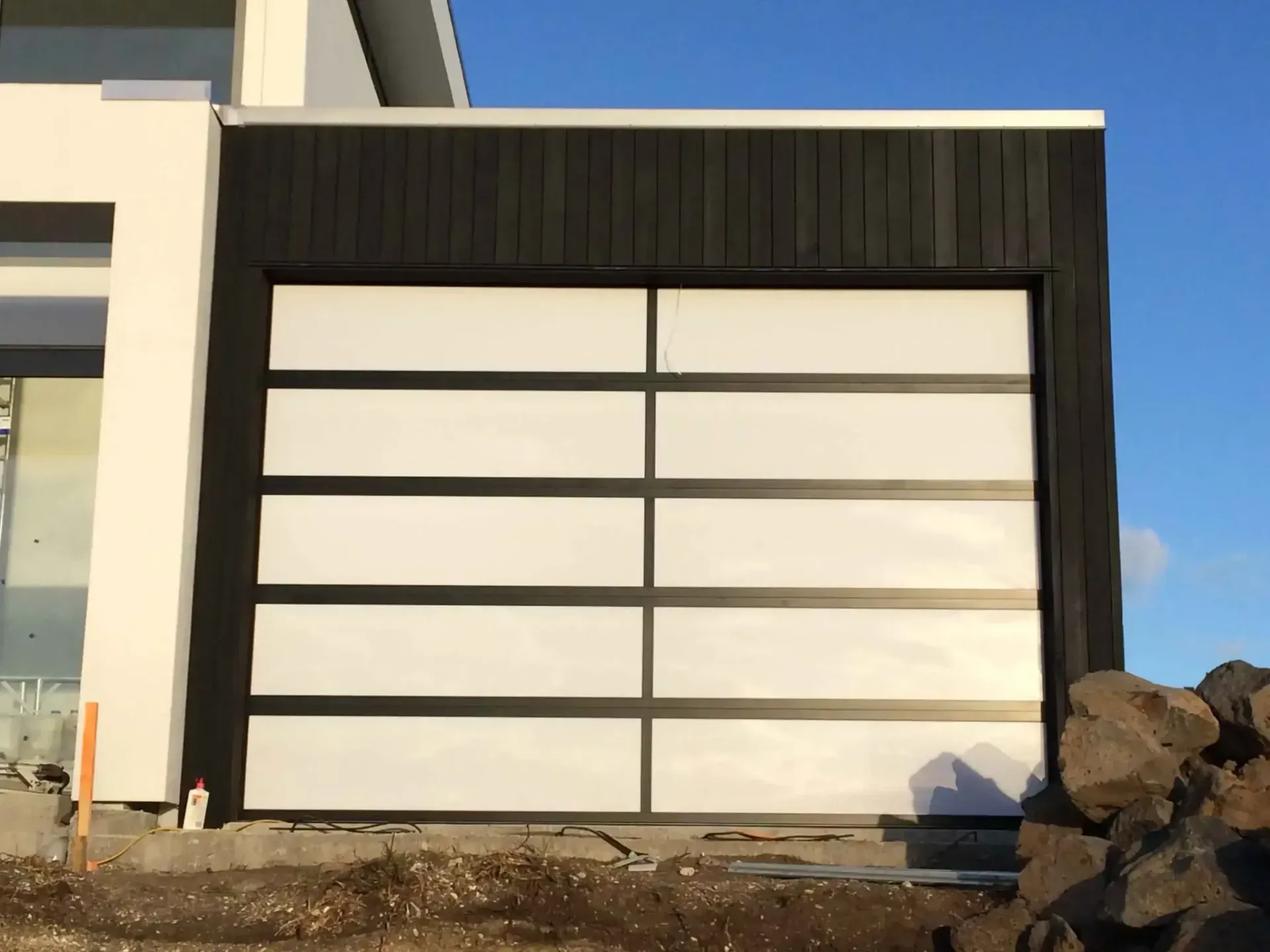A black and white garage door with a clear glass panel