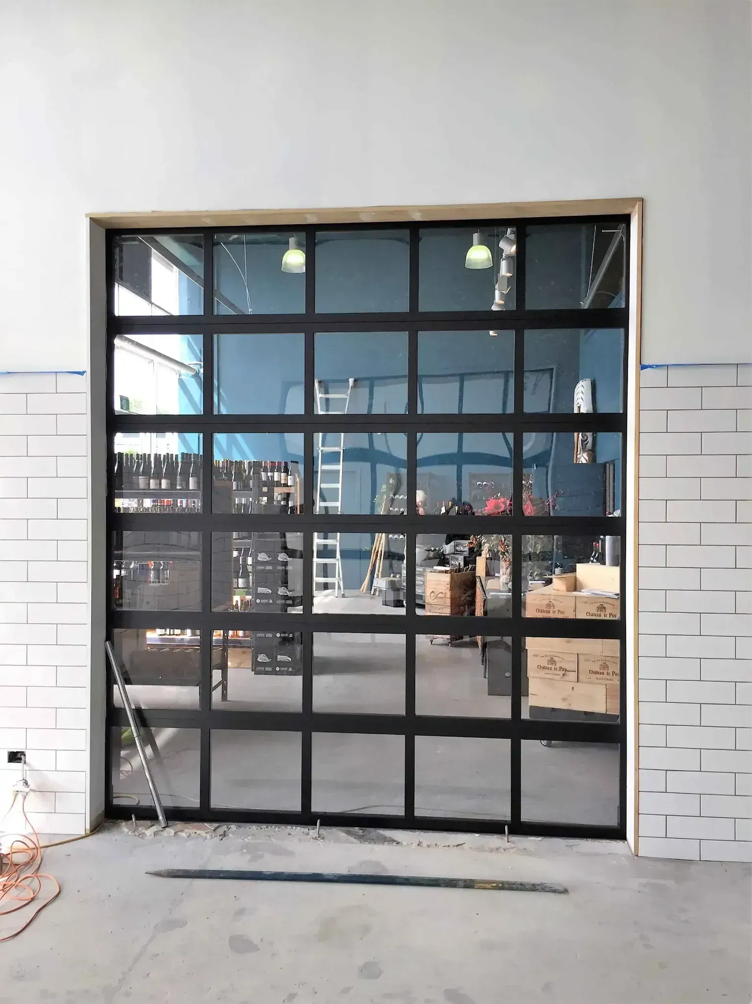 A black garage door is being installed in a building.