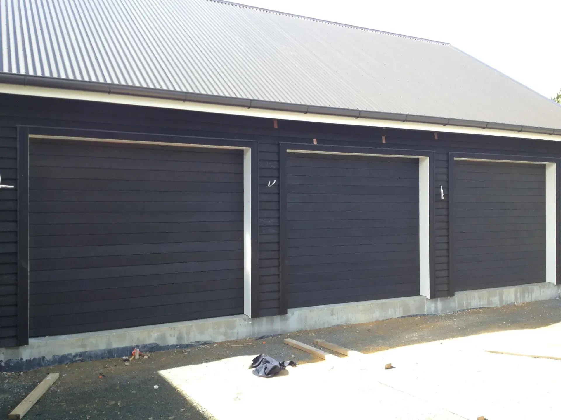A row of black garage doors on a building