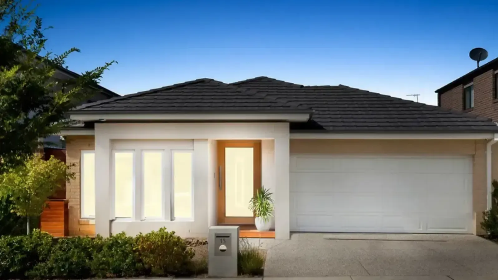 A house with a black roof and a white garage door