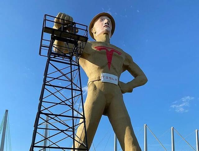 A statue of a man standing next to a tower.