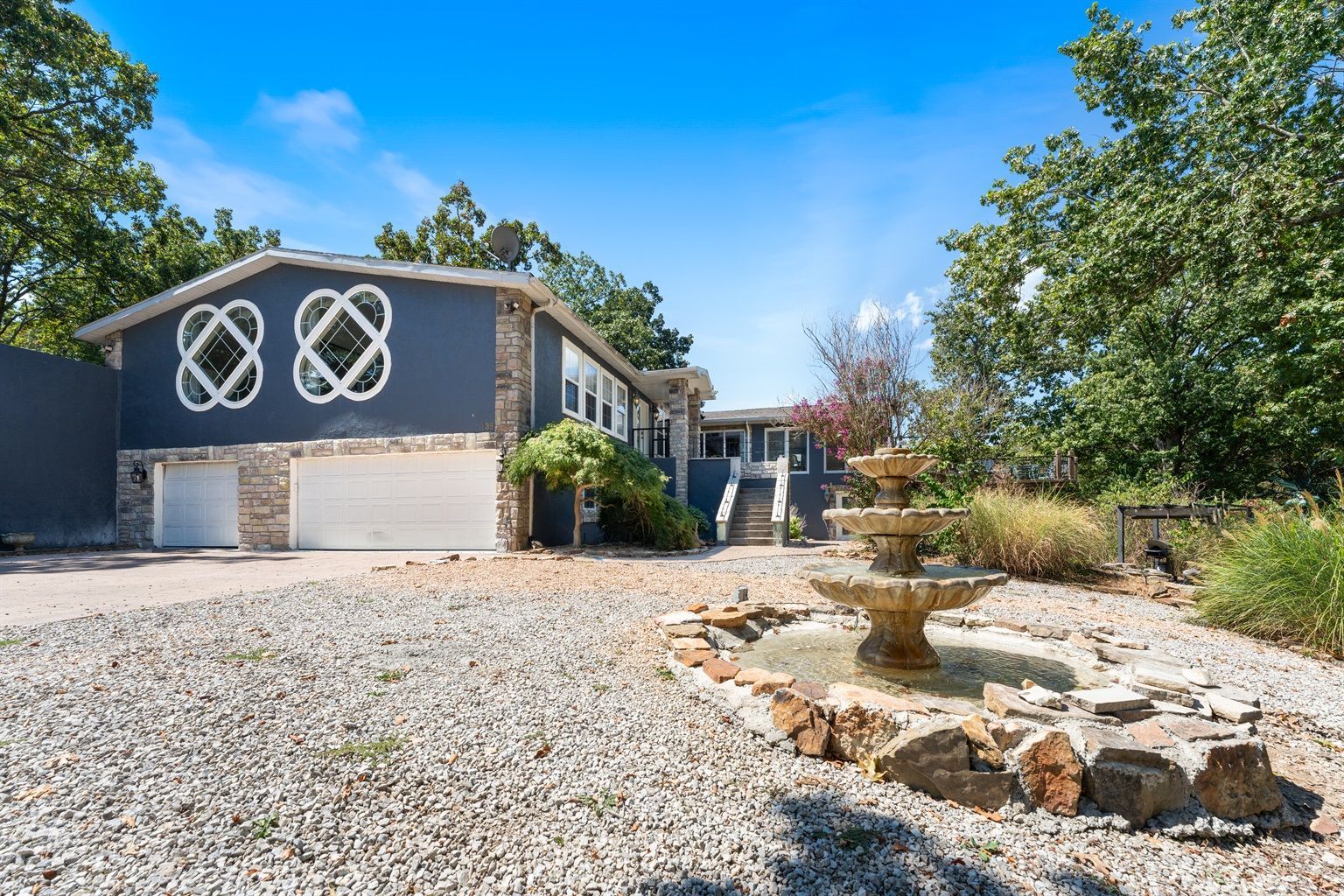 A house with a fountain in front of it.