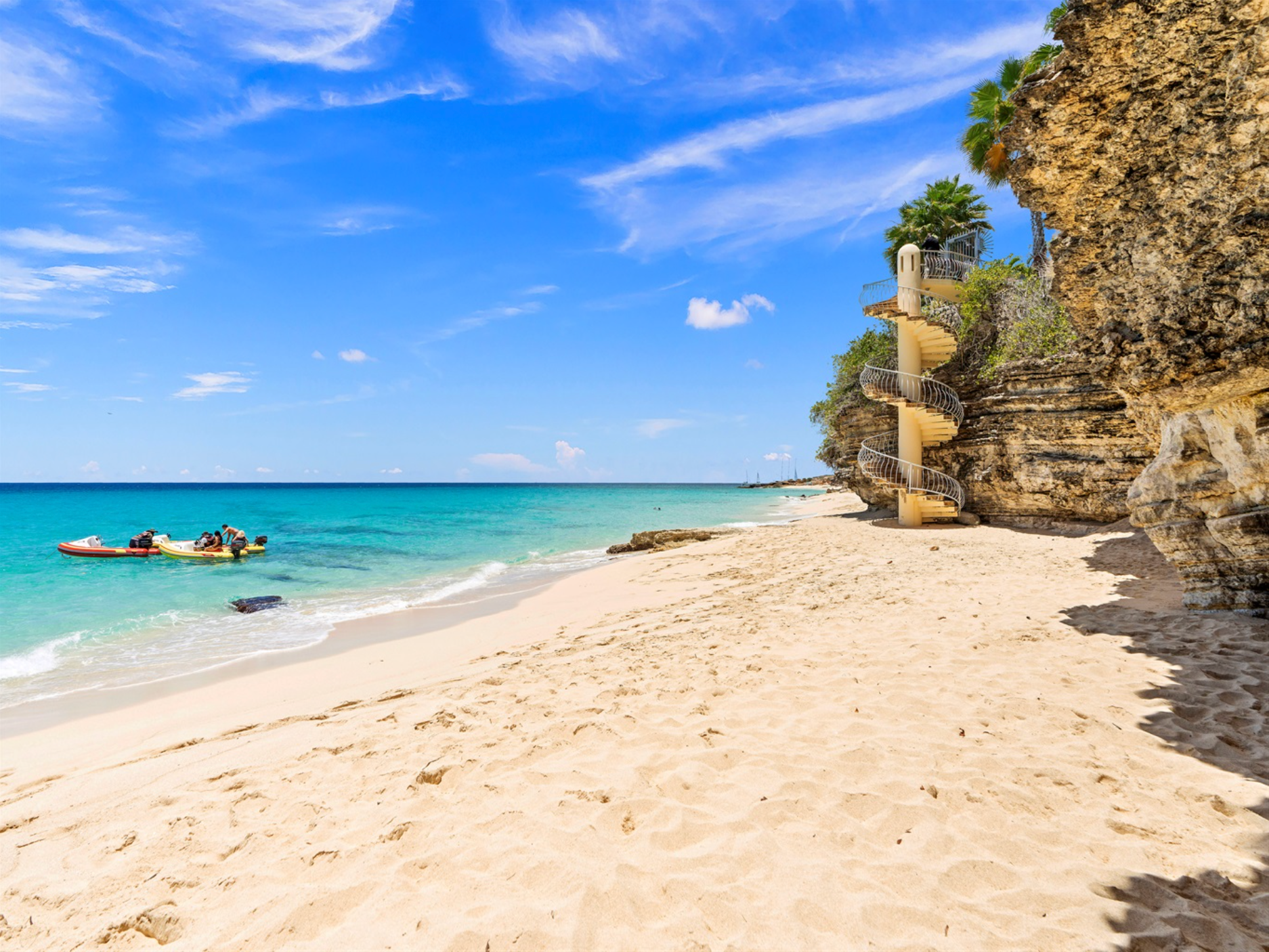 A beach with a slide on the side of the cliff.