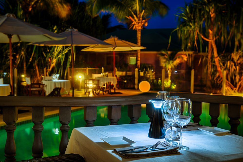 An aerial view of a tropical beach surrounded by rocks and trees.